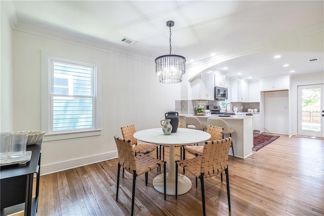 139 Sisson Ave NE, Atlanta, GA 30317 - dining room featuring a chandelier, light wood-style flooring, crown molding, baseboards, and recessed lighting