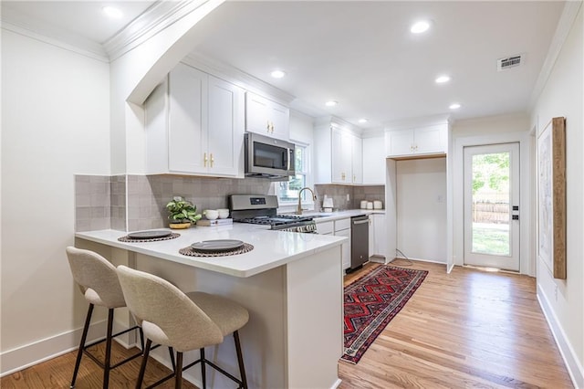 139 Sisson Ave NE, Atlanta, GA 30317 - kitchen featuring stainless steel appliances, crown molding, a sink, light countertops, and a peninsula
