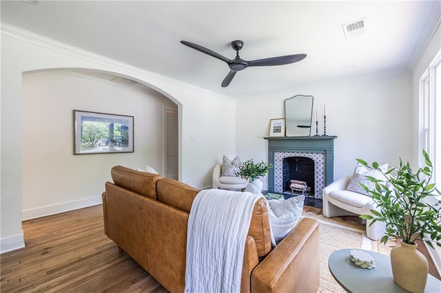 139 Sisson Ave NE, Atlanta, GA 30317 - living room with a tile fireplace, wood finished floors, baseboards, ceiling fan, and ornamental molding