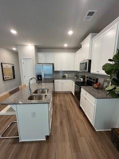 4258 SW Notting Hill Dr Unit 32, Atlanta, GA 30331 - kitchen featuring visible vents, appliances with stainless steel finishes, a sink, a center island with sink, and dark wood-style floors