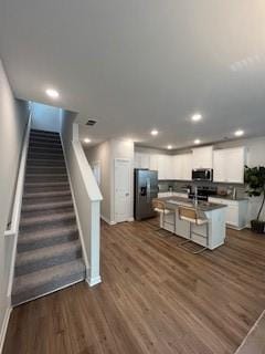4258 SW Notting Hill Dr Unit 32, Atlanta, GA 30331 - kitchen with an island with sink, dark wood finished floors, a kitchen bar, white cabinetry, and appliances with stainless steel finishes
