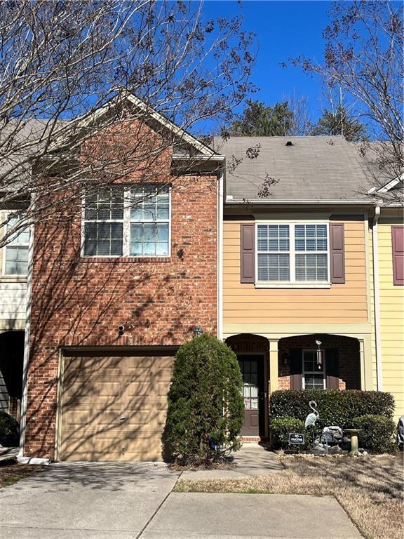 view of front of property with driveway, an attached garage, and brick siding