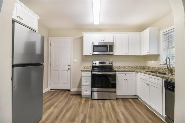 3449 Misty Valley Rd, Decatur, GA 30032 - kitchen with appliances with stainless steel finishes, a sink, light wood-style floors, white cabinetry, and light stone countertops