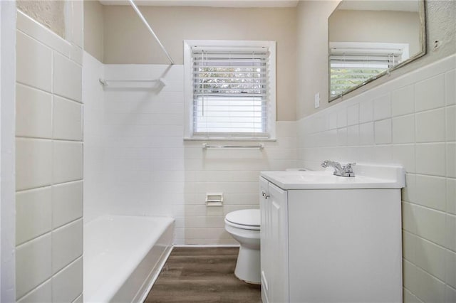 3449 Misty Valley Rd, Decatur, GA 30032 - bathroom featuring tile walls, wood finished floors, toilet, vanity, and  shower combination
