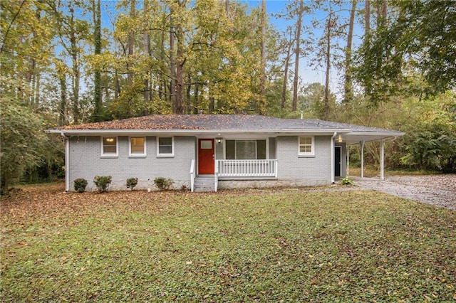 3449 Misty Valley Rd, Decatur, GA 30032 - ranch-style house featuring a porch, gravel driveway, a front yard, brick siding, and a carport