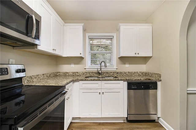 3449 Misty Valley Rd, Decatur, GA 30032 - kitchen featuring stainless steel appliances, a sink, white cabinetry, light stone countertops, and wood finished floors