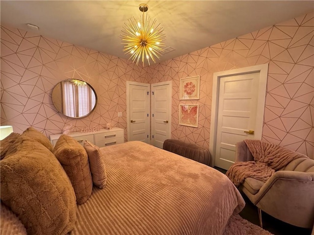 bedroom with a notable chandelier and wallpapered walls