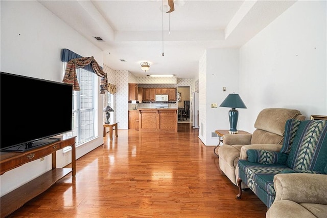 1900 Green Oak Cir, Lawrenceville, GA 30043 - living area featuring a raised ceiling, light wood finished floors, and a ceiling fan