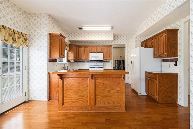 1900 Green Oak Cir, Lawrenceville, GA 30043 - kitchen featuring white appliances, wallpapered walls, a peninsula, wood finished floors, and light countertops