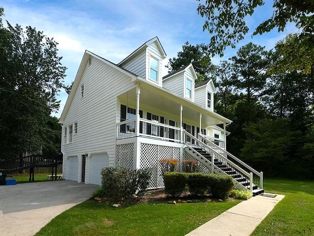 cape cod-style house with a front yard, stairway, driveway, a porch, and a garage