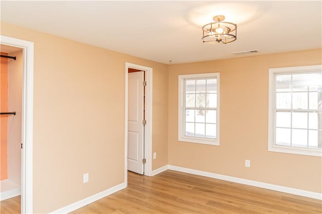 unfurnished room with an inviting chandelier and hardwood / wood-style floors