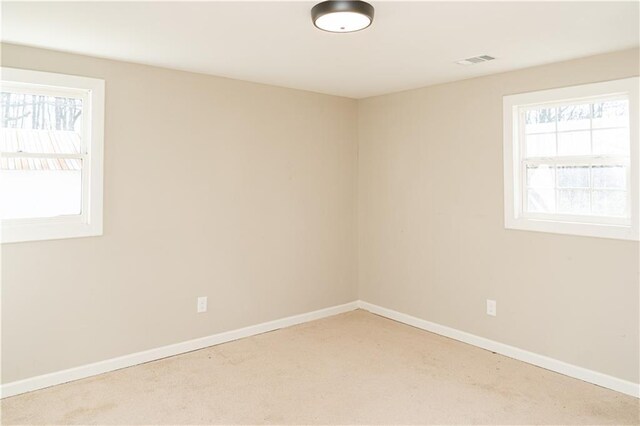 unfurnished bedroom featuring a walk in closet, a closet, and light carpet