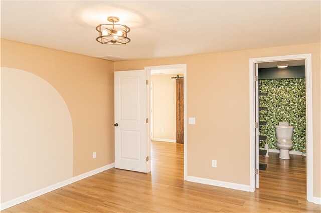 bathroom with toilet, hardwood / wood-style flooring, and tiled shower