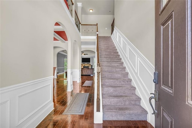 271 Learwood Ln, Atlanta, GA 30349 - foyer entrance with arched walkways, a wainscoted wall, a towering ceiling, stairway, and wood finished floors