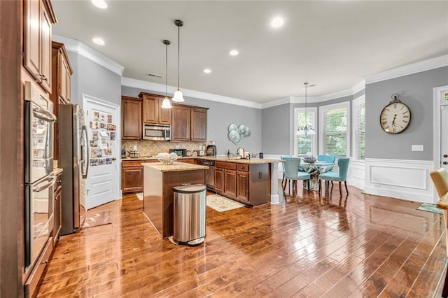 271 Learwood Ln, Atlanta, GA 30349 - kitchen featuring appliances with stainless steel finishes, a kitchen island, crown molding, a peninsula, and a sink