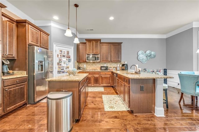 271 Learwood Ln, Atlanta, GA 30349 - kitchen with appliances with stainless steel finishes, a peninsula, crown molding, a kitchen bar, and a kitchen island