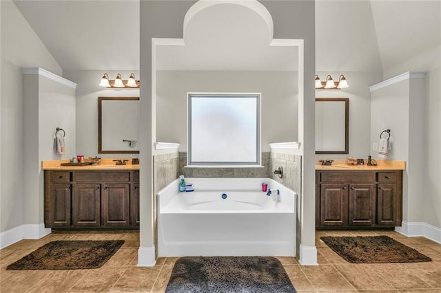271 Learwood Ln, Atlanta, GA 30349 - bathroom featuring vaulted ceiling, tile patterned floors, a garden tub, two vanities, and baseboards