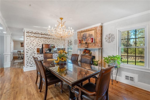 4983 Arcado Rd SW, Lilburn, GA 30047 - dining space featuring light wood-style flooring, an inviting chandelier, visible vents, and crown molding