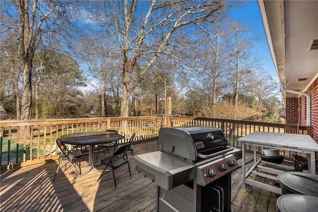 4983 Arcado Rd SW, Lilburn, GA 30047 - wooden deck with outdoor dining area, visible vents, and grilling area