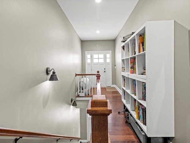 corridor featuring baseboards, wood finished floors, and recessed lighting