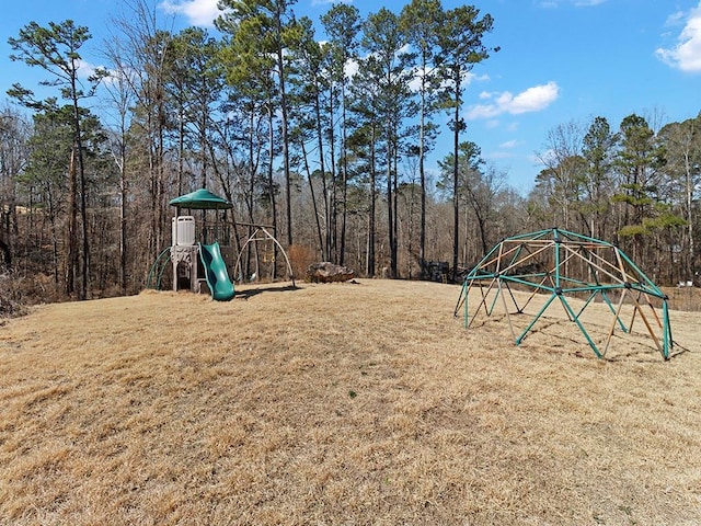 community play area with a lawn and a forest view