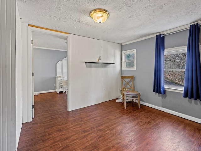 empty room with plenty of natural light, a textured ceiling, and wood finished floors