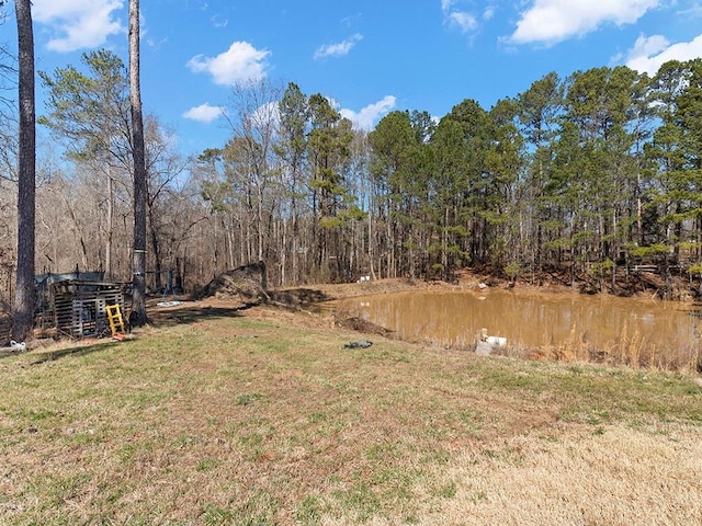 view of yard with a water view and a wooded view