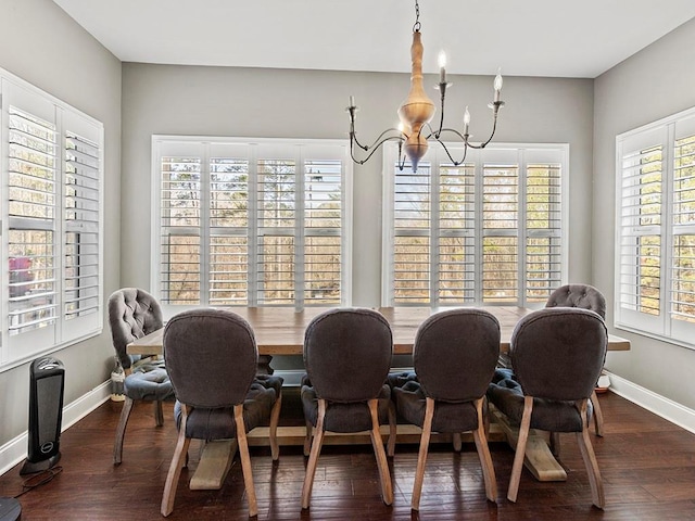 dining room featuring wood finished floors, baseboards, and an inviting chandelier