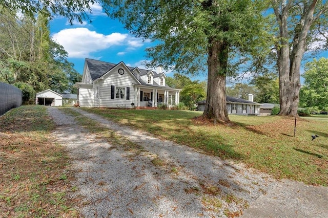 cape cod house with a porch, an outbuilding, fence, and a front lawn