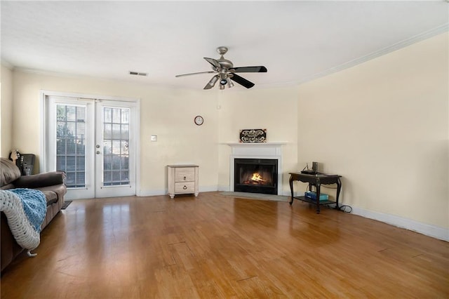 living room featuring crown molding, hardwood / wood-style floors, and ceiling fan