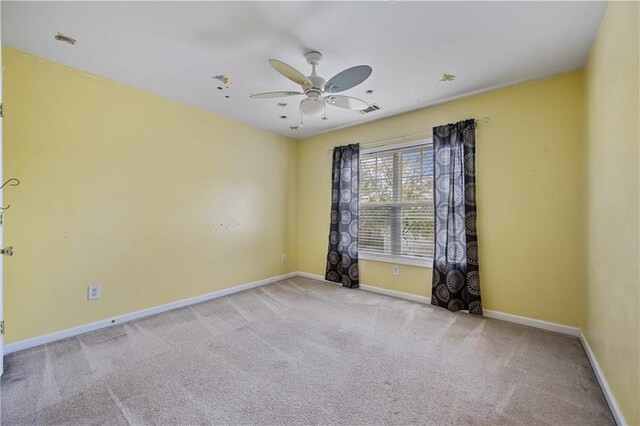 spare room with ceiling fan and light colored carpet