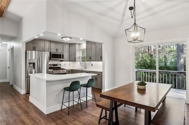 kitchen featuring backsplash, a kitchen island, light countertops, stainless steel appliances, and a sink