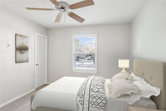 bedroom with light carpet, a ceiling fan, and baseboards