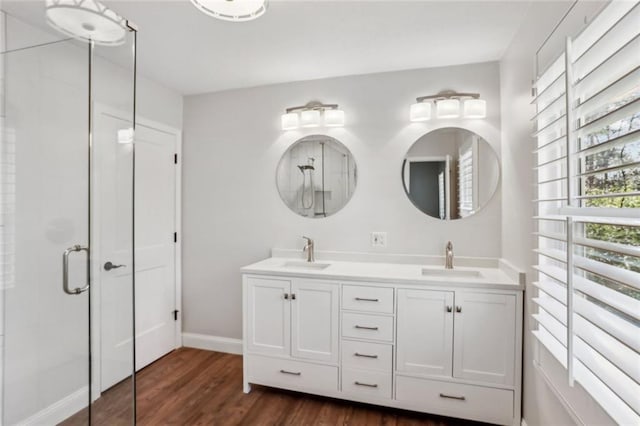 full bath featuring a shower stall, wood finished floors, and a sink