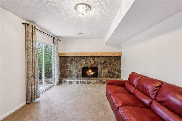 carpeted living room with baseboards, a textured ceiling, and a stone fireplace