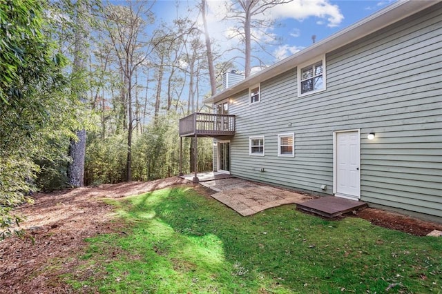 back of house featuring a patio, a yard, and a chimney