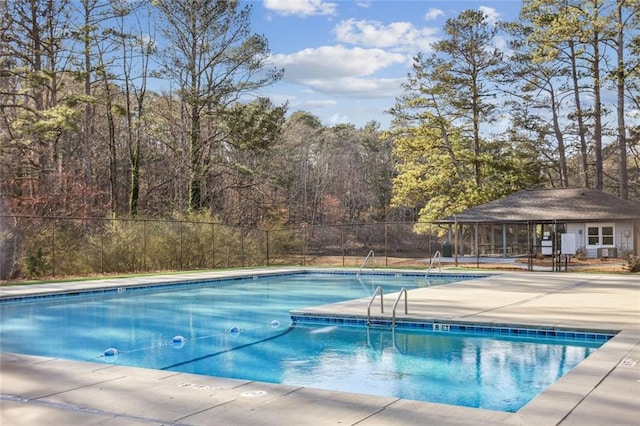 pool with a patio and fence