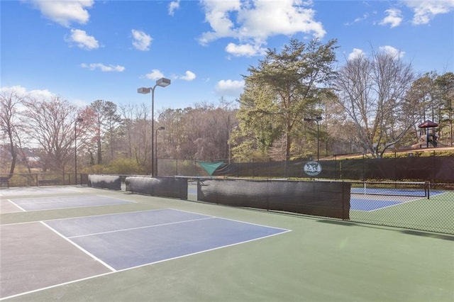 view of sport court featuring playground community and fence