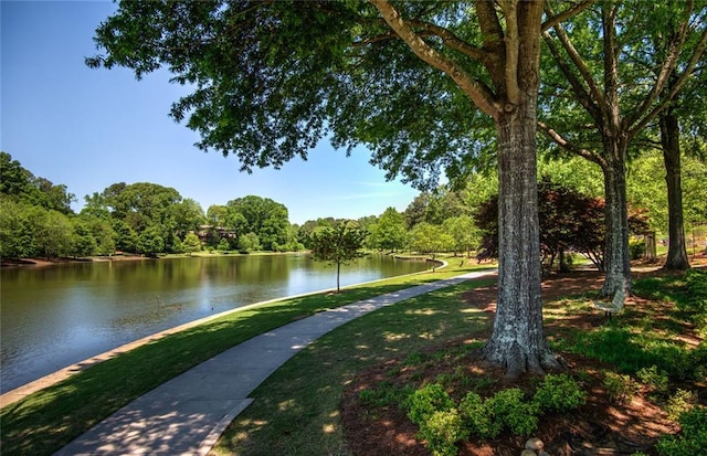 surrounding community featuring a lawn and a water view