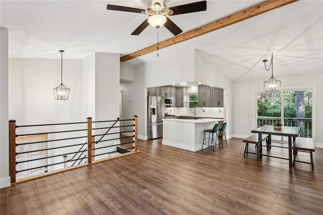 kitchen with gray cabinets, lofted ceiling with beams, appliances with stainless steel finishes, light countertops, and dark wood-style flooring