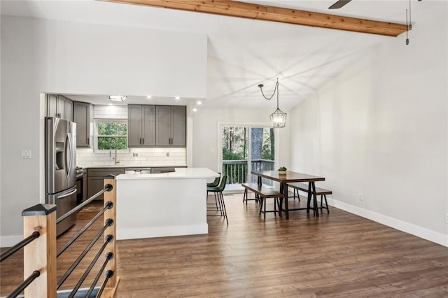 kitchen with dark wood-type flooring, backsplash, stainless steel fridge with ice dispenser, baseboards, and a healthy amount of sunlight