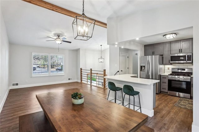 kitchen featuring tasteful backsplash, visible vents, stainless steel appliances, and dark wood-type flooring