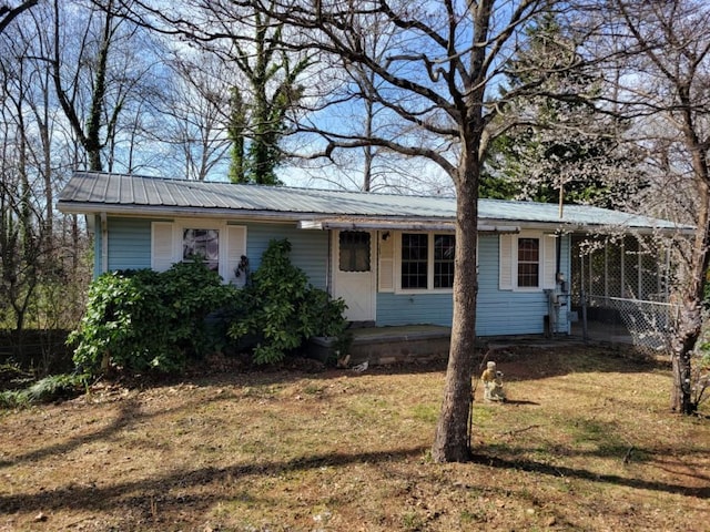 single story home featuring metal roof and a front lawn