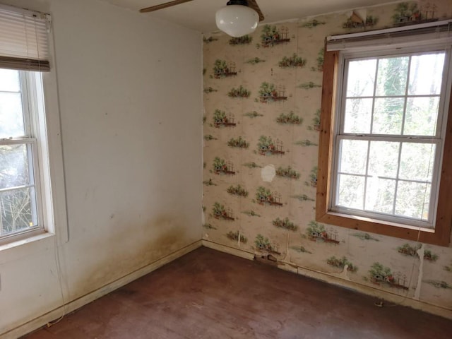 unfurnished room with wallpapered walls, baseboards, and a wealth of natural light