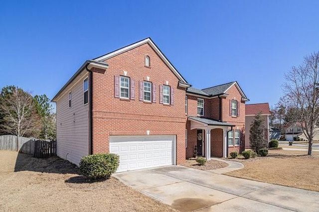 traditional-style house with brick siding, concrete driveway, a garage, and fence