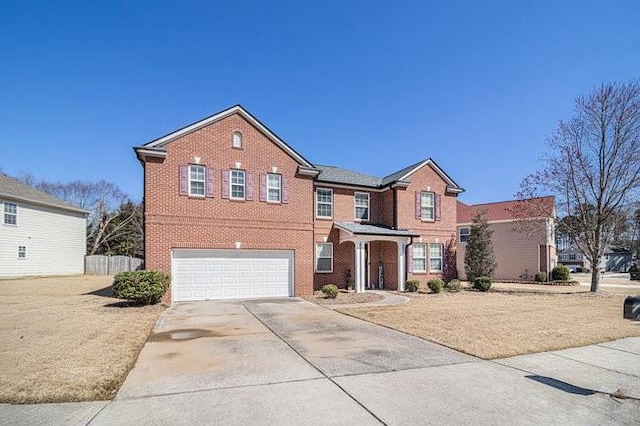 traditional home with brick siding, concrete driveway, a garage, and fence