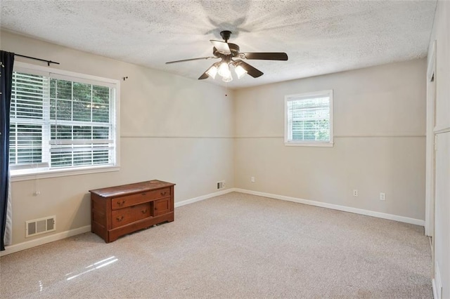 2026 Mcdaniel Mill Rd SW, Conyers, GA 30094 - empty room with healthy amount of natural light, carpet flooring, a ceiling fan, and a textured ceiling