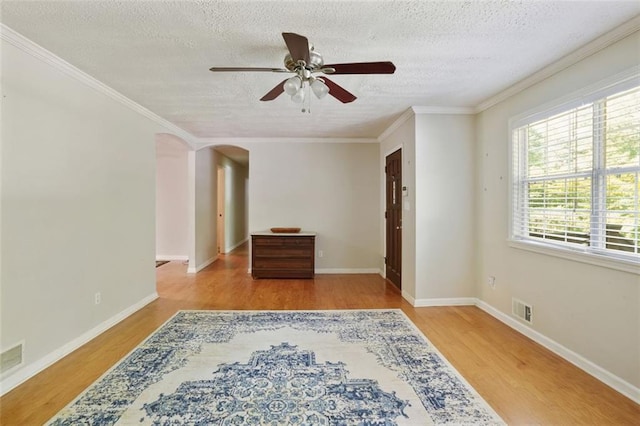 2026 Mcdaniel Mill Rd SW, Conyers, GA 30094 - spare room featuring ceiling fan, wood finished floors, a textured ceiling, crown molding, and arched walkways