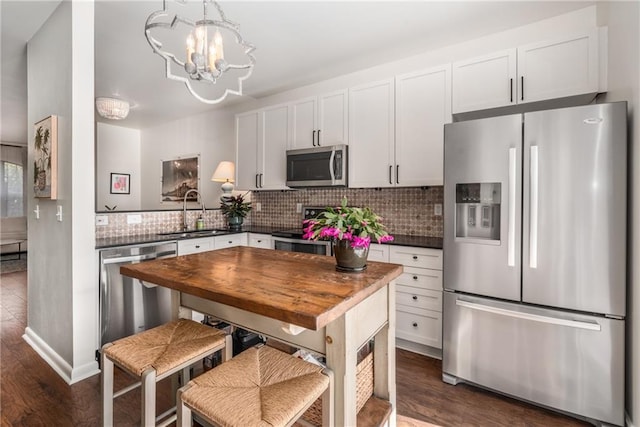 kitchen with white cabinetry, sink, backsplash, and appliances with stainless steel finishes