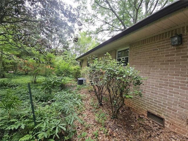 view of home's exterior featuring central air condition unit, crawl space, and brick siding